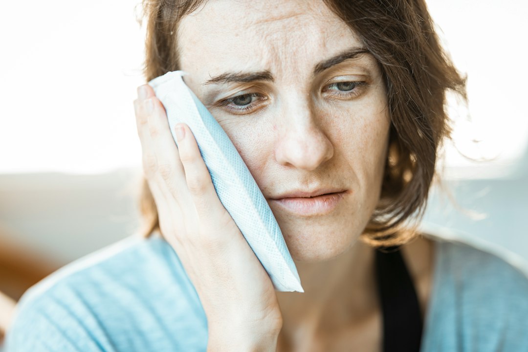Woman with a toothache holding her cheek